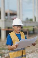 Engineering Consulting People on construction site holding blueprint in his hand. Building inspector. Construction site check drawing and business workflow of new building photo
