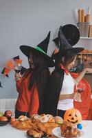 friendship, holiday and people concept - group of happy smiling friends in halloween costumes of vampire, devil, witch and cheetah at home party photo