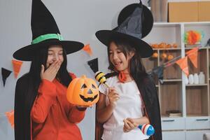 friendship, holiday and people concept - group of happy smiling friends in halloween costumes of vampire, devil, witch and cheetah at home party photo