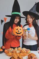 friendship, holiday and people concept - group of happy smiling friends in halloween costumes of vampire, devil, witch and cheetah at home party photo