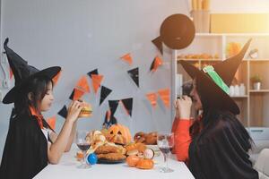 friendship, holiday and people concept - group of happy smiling friends in halloween costumes of vampire, devil, witch and cheetah at home party photo
