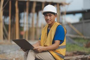Asian man architect holds blueprint with skyscraper background, Asian male architect builder engineer design working planning confident outdoors in construction site. photo