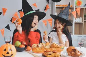 friendship, holiday and people concept - group of happy smiling friends in halloween costumes of vampire, devil, witch and cheetah at home party photo