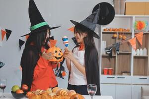 friendship, holiday and people concept - group of happy smiling friends in halloween costumes of vampire, devil, witch and cheetah at home party photo