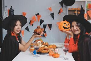 friendship, holiday and people concept - group of happy smiling friends in halloween costumes of vampire, devil, witch and cheetah at home party photo