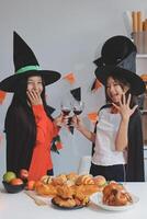 friendship, holiday and people concept - group of happy smiling friends in halloween costumes of vampire, devil, witch and cheetah at home party photo