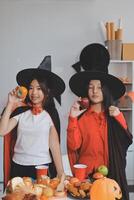 friendship, holiday and people concept - group of happy smiling friends in halloween costumes of vampire, devil, witch and cheetah at home party photo