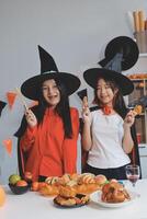 friendship, holiday and people concept - group of happy smiling friends in halloween costumes of vampire, devil, witch and cheetah at home party photo