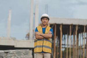 Asian man architect holds blueprint with skyscraper background, Asian male architect builder engineer design working planning confident outdoors in construction site. photo