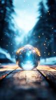 glowing crystal ball on wooden path in snowy forest photo