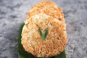 Indonesian Traditional Coconut Cake called Sagon on Banana Leaf with Rustic Background Setting photo