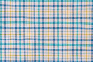 Checkered fabric in blue, white and yellow as a background. photo
