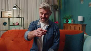 Middle-aged old smiling man pointing to camera, choosing lucky winner, indicating, inviting, approve video