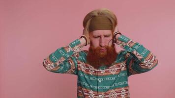 Irritated hippie man covering ears gesturing no avoiding advice ignoring unpleasant noise loud voice video