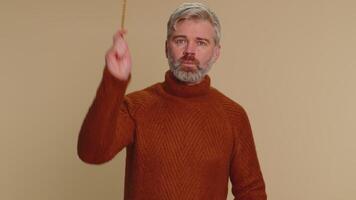Magician wizard senior man gesturing with magic wand making wish come true, casting magician spell video