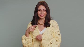 Woman showing a little bit gesture with sceptic smile, showing minimum sign, measuring small size video