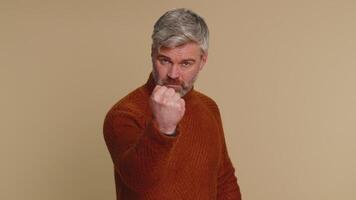 Aggressive angry man trying to fight at camera, shaking fist, boxing with expression, punishment video