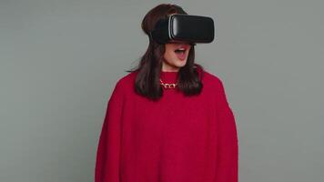 Young woman using virtual reality headset helmet to play simulation game app, watching content video