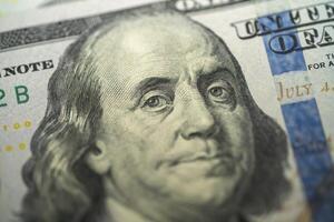 Close-up view of a hundred dollar bill with intricate details photo