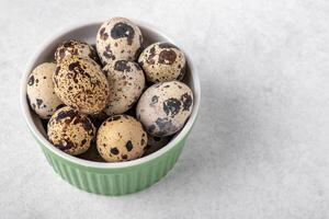 A dish with quail eggs placed on a textured surface. Concept of healthy eating photo