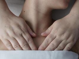 The masseur massages the client in the thoracic area of the collarbone. Close-up, no face photo