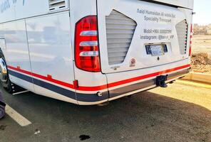 Medina, February 28, 2024. White Bus with Red and Gray Stripes, Aaid Humaidan, for Transport Services photo