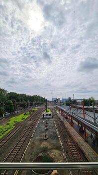 Bekasi, Indonesia on 3 February 2024. High-Angle View of a Busy Train Station on an Overcast Day photo