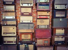 A wall display showcasing a diverse collection of vintage radios in various shapes, sizes, and colors. photo