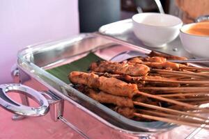 Chicken satay with peanut sauce served in a buffet lunch. Self-service catering menu for small parties. photo
