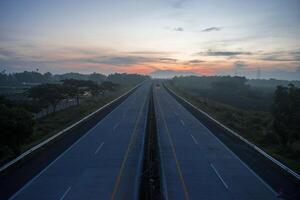 Top view of the highway with a mountain in the background in the morning. photo
