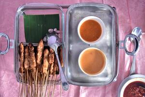 Flat lay view of chicken satay with peanut sauce served in a buffet lunch. Self-service catering menu for small parties. photo