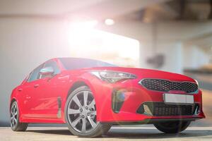 A red car on a background of city environment. Stylish, modern, bright image of the car for design solutions. photo