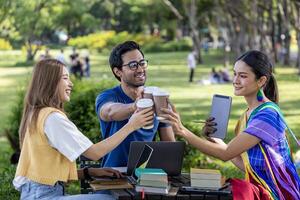 Diverse group of college student is meeting and working on thesis and project outside in the university campus garden during summer photo