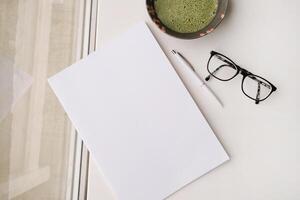 blank magazine mockup on coffee table with green matcha tea near window photo