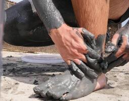 People are wiped with mud. a Mud baths in Spain. photo