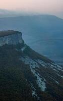 Dawn in the mountains of Crimea. light haze of mist over the mountains and rays of the sun through the clouds. photo