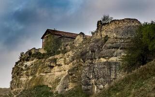 old limestone house on a cliff on the edge of a cliff. photo