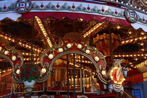 A Beautiful and Colorful Vintage Carousel Brightly Adorned with Illuminated Lights photo