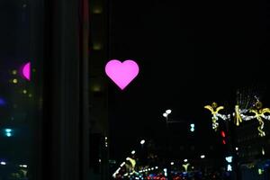 A beautiful night cityscape adorned with a vibrant pink heart and mesmerizing lights photo