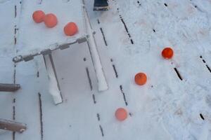 Bright orange balls scattered across a snowy surface create a vibrant and joyful scene photo