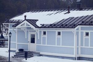 Charming Blue House Set in a Snowy Winter Landscape, creating a calming atmosphere photo