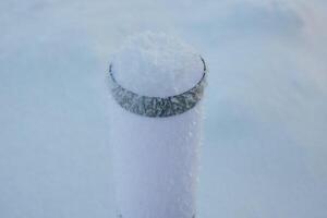 A Majestic SnowCovered Post Standing Proudly in a Beautiful Winter Landscape Scene photo