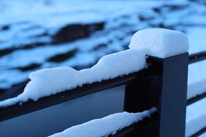 A Beautiful SnowCovered Railing Surrounded by a Picturesque Winter Landscape Scene photo