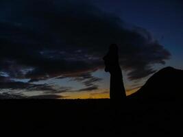 Statues of Easter Island in the background of the sunset. melting of the Easter statue in the sunlight of the sunset. photo