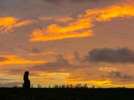 Statues of Easter Island in the background of the sunset. melting of the Easter statue in the sunlight of the sunset. photo