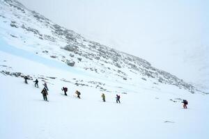 Skiers ride in the snow in the mountains of Baikal photo