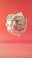 Crumpled Paper Ball floating in red background photo