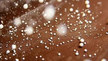 Abstract background with bokeh effect of many white shiny balls on a brown background. video