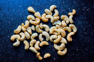 Roasted cashew nuts on the black background. Toned. photo