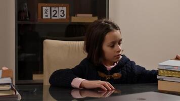 Young child arranging books on desk in a library or study setting photo